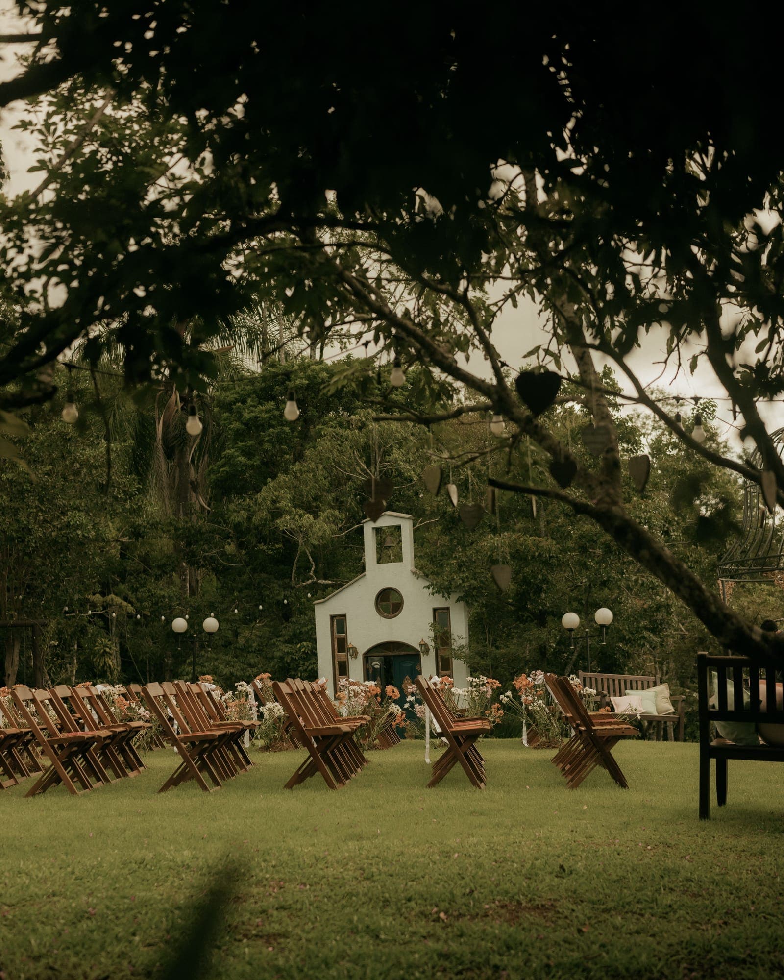 Capela branca no jardim com cadeiras para a cerimônia